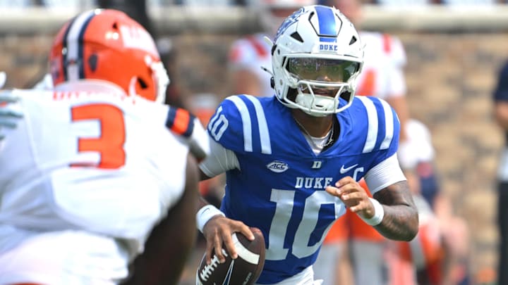 Sep 6, 2025; Durham, North Carolina, USA;  Duke Blue Devils quarterback Darian Mensah (10) scrambles against Illinois Fighting Illini linebacker Alec Bryant (3) during the fourth quarter at Wallace Wade Stadium. Mandatory Credit: Zachary Taft-Imagn Images