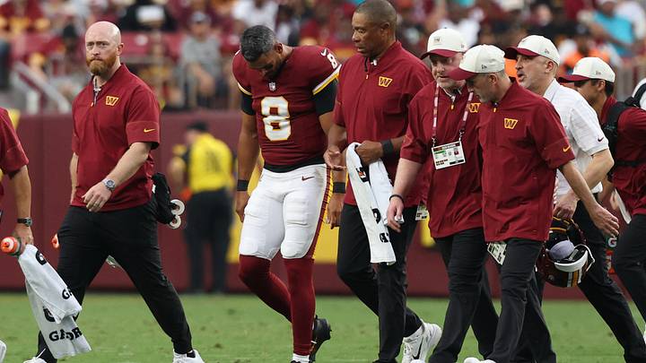 Aug 14, 2026; Landover, Maryland, USA; Washington Commanders quarterback Marcus Mariota (8) is escorted off the field by Commanders medical staff after being injured against the Miami Dolphins during the first half at Northwest Stadium. Mandatory Credit: Geoff Burke-Imagn Images