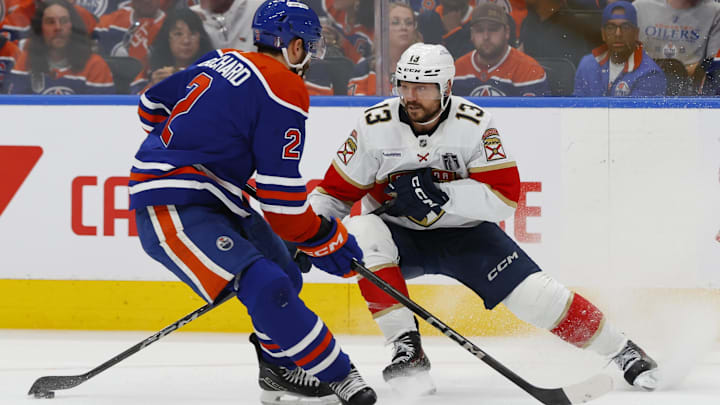 Jun 4, 2025; Edmonton, Alberta, CAN; Edmonton Oilers defenseman Evan Bouchard (2) and Florida Panthers center Sam Reinhart (13) attempt to get a loose puck in the second period in game one of the 2025 Stanley Cup Final at Rogers Place. Mandatory Credit: Perry Nelson-Imagn Images