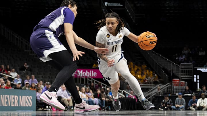 Mar 7, 2025; Kansas City, MO, USA; West Virginia Mountaineers guard JJ Quinerly (11) handles the ball while defended by Kansas State Wildcats forward Imani Lester (32) in the second quarter at T-Mobile Center. 