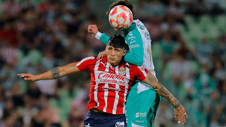 Alan Pulido y Haret Ortega buscan la pelota en el aire