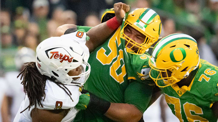 Oregon offensive linemen Nishad Strother, center, and Josh Conerly Jr., right, engage Maryland defensive lineman Jordan Phillips as the Oregon Ducks host the Maryland Terrapins at Autzen Stadium Saturday, Nov. 9, 2024 in Eugene, Ore.