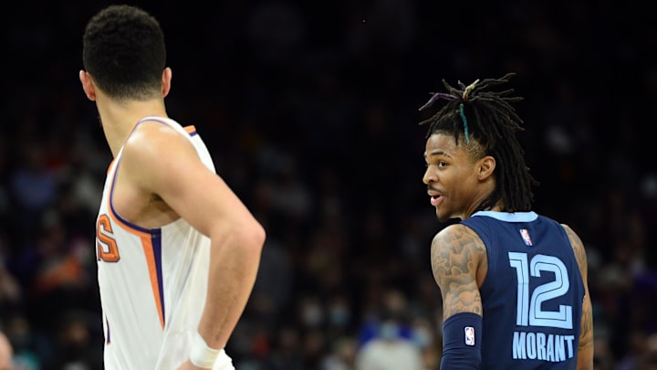 Dec 27, 2021; Phoenix, Arizona, USA; Memphis Grizzlies guard Ja Morant (12) has words with Phoenix Suns guard Devin Booker (1) during the second half at Footprint Center. Mandatory Credit: Joe Camporeale-Imagn Images