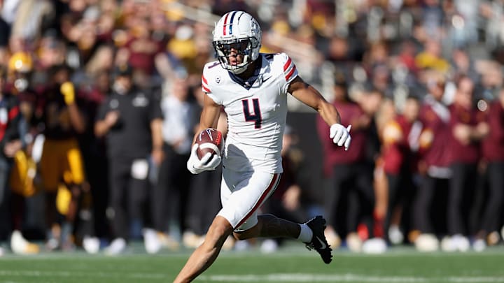 Wide receiver Tetairoa McMillan #4 of the Arizona Wildcats runs with the football after a reception against the Arizona State Sun Devils during the first half of the NCAAF game at Mountain America Stadium on November 25, 2023 in Tempe, Arizona.