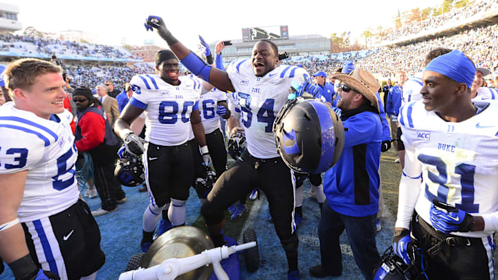 Nov 30, 2013; Chapel Hill, NC, USA; Duke Blue Devils linebacker Chris Hoover (53) and tight end David Reeves (80) and defensive end Kenny Anunike (84) and cornerback Breon Borders (31) with the victory bell after the game. The Duke Blue Devils defeated the North Carolina Tar Heels 27-25 at Kenan Memorial Stadium. Mandatory Credit: Bob Donnan-Imagn Images Nov 30, 2013; Chapel Hill, NC, USA; Duke Blue Devils linebacker Chris Hoover (53) and tight end David Reeves (80) and defensive end Kenny Anunike (84) and cornerback Breon Borders (31) with the victory bell after the game. The Duke Blue Devils defeated the North Carolina Tar Heels 27-25 at Kenan Memorial Stadium. Mandatory Credit: Bob Donnan-Imagn Images