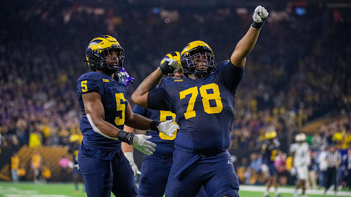 Josaiah Stewart #5, Mason Graham #55, and Kenneth Grant #78 of Michigan Wolverines celebrate after a play during the second half of the 2024 CFP National Championship game against the Washington Huskies at NRG Stadium on January 08, 2024 in Houston, Texas. The Michigan Wolverines won the game 34-13.