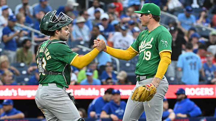 Aug 10, 2024; Toronto, Ontario, CAN; Oakland Athletics catcher Shea Langeliers (23) and pitcher Mason Miller (19) celebrate the win against the Toronto Blue Jays at Rogers Centre. Mandatory Credit: Gerry Angus-Imagn Images