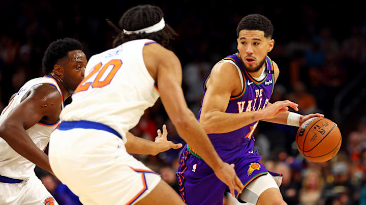Nov 20, 2024; Phoenix, Arizona, USA; Phoenix Suns guard Devin Booker (1) drives to the basket against New York Knicks forward OG Anunoby (8) and center Jericho Sims (20) during the first quarter at Footprint Center. Mandatory Credit: Mark J. Rebilas-Imagn Images