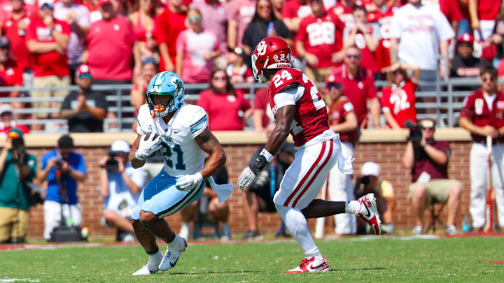Sep 14, 2024; Norman, Oklahoma, USA;  Tulane Green Wave running back Makhi Hughes (21) runs with the ball as Oklahoma Sooners linebacker Samuel Omosigho (24) defends during the first half at Gaylord Family-Oklahoma Memorial Stadium. Mandatory Credit: Kevin Jairaj-Imagn Images