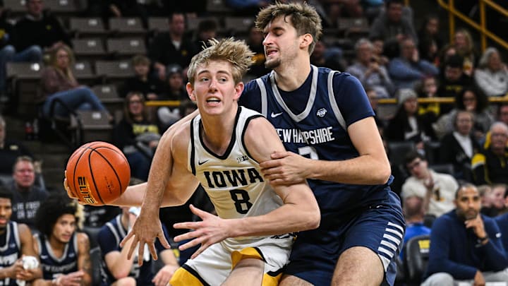 Dec 30, 2024; Iowa City, Iowa, USA; Iowa Hawkeyes forward Cooper Koch (8) is fouled by New Hampshire Wildcats forward Dylan Saunders (3) during the first half at Carver-Hawkeye Arena. Mandatory Credit: Jeffrey Becker-Imagn Images