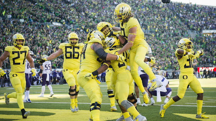 Teammates mob CJ Verdell after a game-winning touchdown against Washington in overtime in 2018. Ducks won 30-27.  Mandatory Credit: Troy Wayrynen-Imagn Images