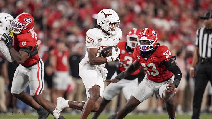 Texas Longhorns wide receiver Ryan Wingo runs with the ball while pursued by Georgia Bulldogs linebacker Quintavius Johnson in the first half at Sanford Stadium.