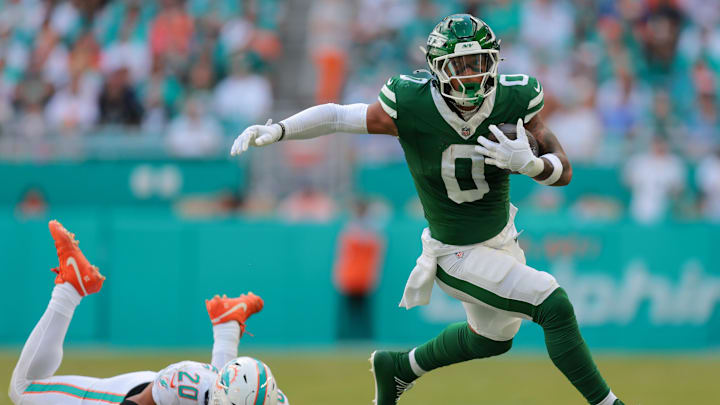 Dec 8, 2024; Miami Gardens, Florida, USA; New York Jets running back Braelon Allen (0) runs past Miami Dolphins linebacker Jordyn Brooks (20) during the first quarter at Hard Rock Stadium.