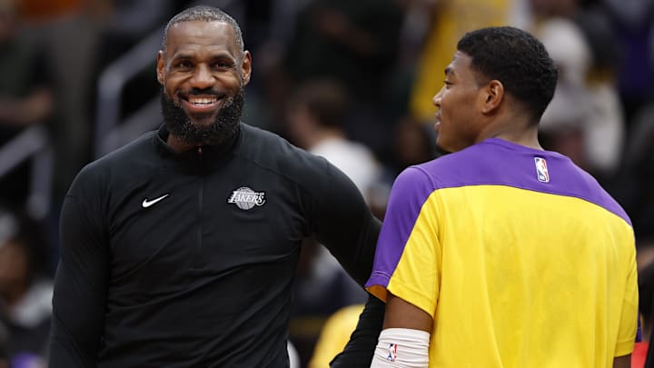 Los Angeles Lakers forward LeBron James (L) and Lakers forward Rui Hachimura (R) joke on the bench against the Washington Wizards in the third quarter at Capital One Arena.