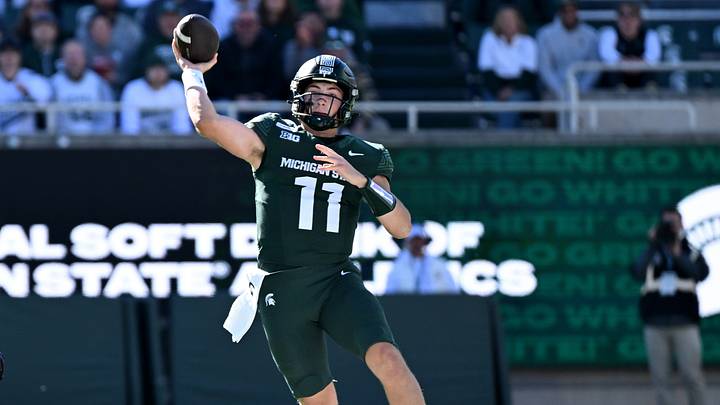 Oct 17, 2026; East Lansing, Michigan, USA;  Michigan State Spartans quarterback Alessio Milivojevic (11) leaps and throws against the Northwestern Wildcats during the first quarter at Spartan Stadium.  Mandatory Credit: Dale Young-Imagn Images