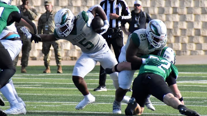 DeSoto's SaRod Baker (5) runs the ball during the first quarter of a playoff game on Saturday against Southlake Carroll.
