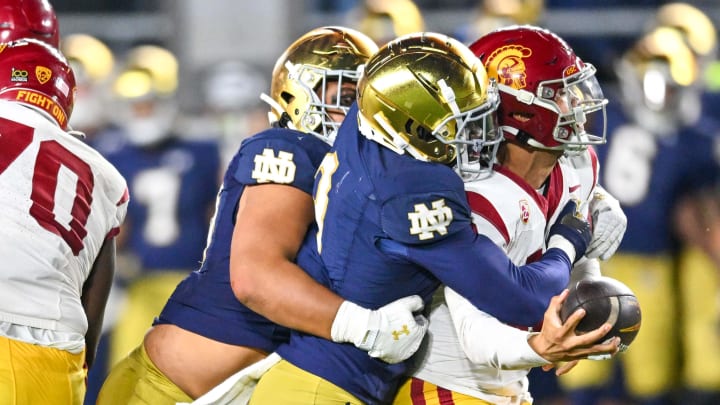 Oct 14, 2023; South Bend, Indiana, USA; USC Trojans quarterback Caleb Williams (13) is tackled by Notre Dame Fighting Irish linebacker Jaylen Sneed (3) and defensive lineman Howard Cross III (56) in the fourth quarter at Notre Dame Stadium. Notre Dame won 48-20. Oct 14, 2023; South Bend, Indiana, USA; USC Trojans quarterback Caleb Williams (13) is tackled by Notre Dame Fighting Irish linebacker Jaylen Sneed (3) and defensive lineman Howard Cross III (56) in the fourth quarter at Notre Dame Stadium. Notre Dame won 48-20.