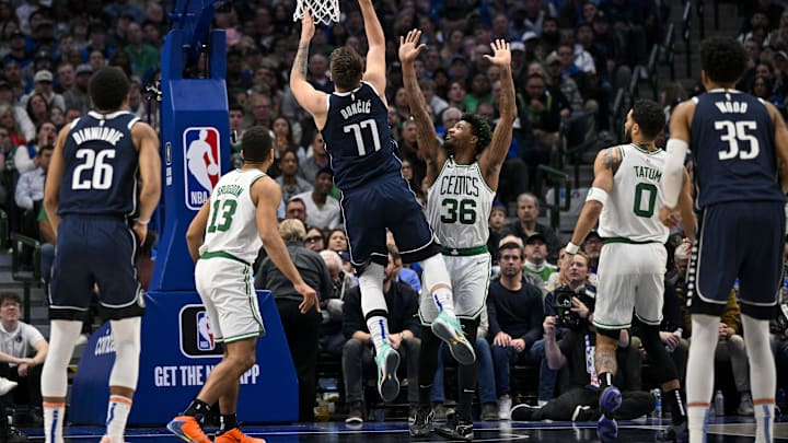 Jan 5, 2023; Dallas, Texas, USA; Dallas Mavericks guard Luka Doncic (77) makes a jump shot over Boston Celtics guard Malcolm Brogdon (13) and guard Marcus Smart (36) and forward Jayson Tatum (0) during the second quarter at the American Airlines Center. Mandatory Credit: Jerome Miron-Imagn Images