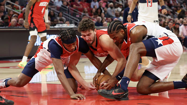 Nov 11, 2024; Houston, Texas, USA;  Houston Rockets center Alperen Sengun (28) and Washington Wizards guard Bilal Coulibaly (0) and forward Alexandre Sarr (20) fight over a loose ball in the second half at Toyota Center. Mandatory Credit: Thomas Shea-Imagn Images