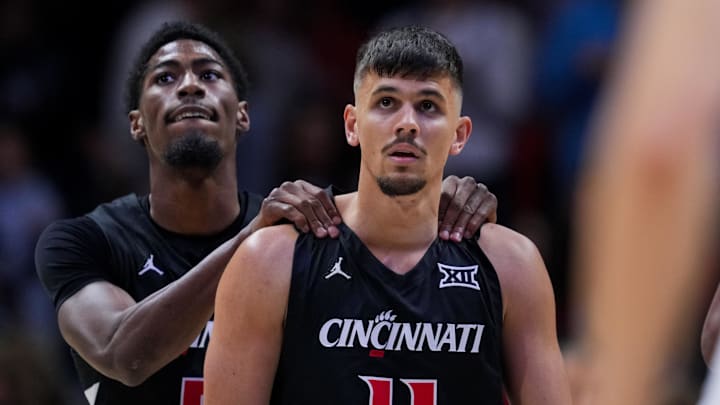 Dec 5, 2025; Cincinnati, Ohio, USA;  Cincinnati Bearcats guard Kerr Kriisa (11) walks off the court with guard Sencire Harris (5) during a stop in play against the Xavier Musketeers in the second half at the Cintas Center. Mandatory Credit: Aaron Doster-Imagn Images