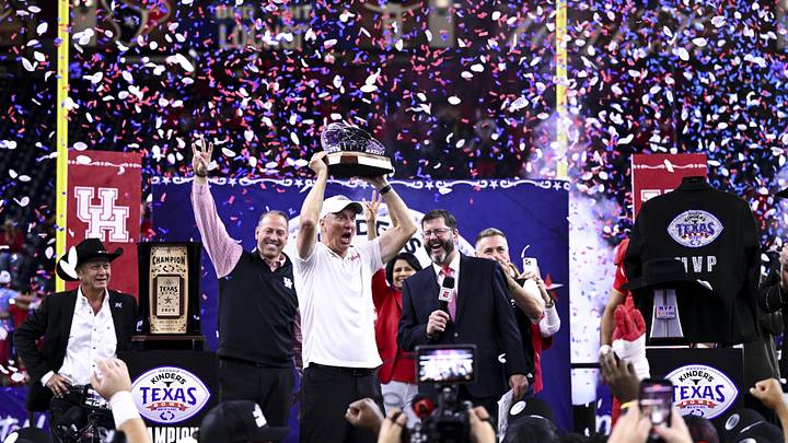Dec 27, 2025; Houston, TX, USA; Houston Cougars head coach Willie Fritz hoists the Texas Bowl trophy after the win over Louisiana State Tigers at NRG Stadium. Mandatory Credit: Maria Lysaker-Imagn Images Dec 27, 2025; Houston, TX, USA; Houston Cougars head coach Willie Fritz hoists the Texas Bowl trophy after the win over Louisiana State Tigers at NRG Stadium. Mandatory Credit: Maria Lysaker-Imagn Images