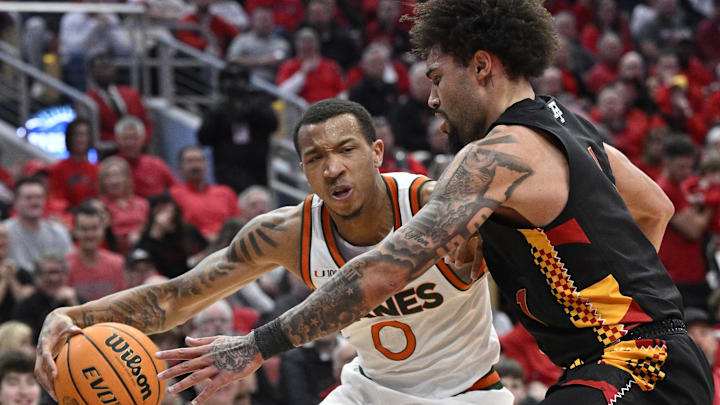Feb 8, 2025; Louisville, Kentucky, USA;  Miami (Fl) Hurricanes guard Matthew Cleveland (0) drives to the basket against Louisville Cardinals guard J'Vonne Hadley (1) during the first half at KFC Yum! Center. Louisville defeated Miami 88-78. Mandatory Credit: Jamie Rhodes-Imagn Images