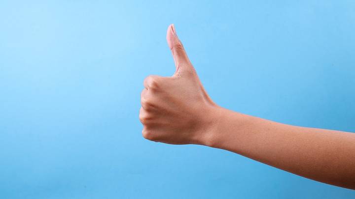 Thumbs up against blue background