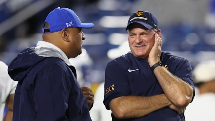 Provo, Utah, USA; West Virginia Mountaineers head coach Rich Rodriguez (right) speaks with Brigham Young Cougars head coach Kalani Sitake before the game at LaVell Edwards Stadium. 