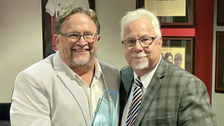 Tommy Hicks inducts Kent Partridge into the Alabama Sports Writers Association's Hall of Honors on Jan. 9, 2024