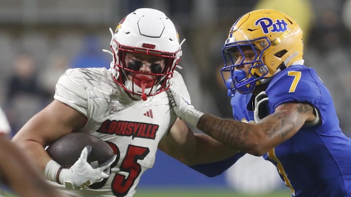 Oct 14, 2023; Pittsburgh, Pennsylvania, USA; Louisville Cardinals tight end Nate Kurisky (85) runs after a catch as  Pittsburgh Panthers defensive back Javon McIntyre (7) defends during the second quarter at Acrisure Stadium. 