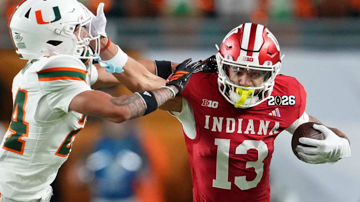 Jan 19, 2026; Miami Gardens, FL, USA; Indiana Hoosiers wide receiver Elijah Sarratt (13) runs with the ball against Miami Hurricanes defensive back Ethan O'Connor (24) during the first half of the College Football Playoff National Championship game at Hard Rock Stadium. Mandatory Credit: Kirby Lee-Imagn Images