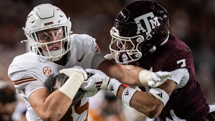 Nov 30, 2024; College Station, Texas, USA; Texas Longhorns tight end Gunnar Helm (85) holds onto the ball as Texas A&M Aggies defensive back Tyreek Chappell (7) goes for the tackle in the second quarter of the Lone Star Showdown against the Texas A&M Aggies at Kyle Field. Mandatory Credit: Sara Diggins/USA TODAY Network via Imagn Images