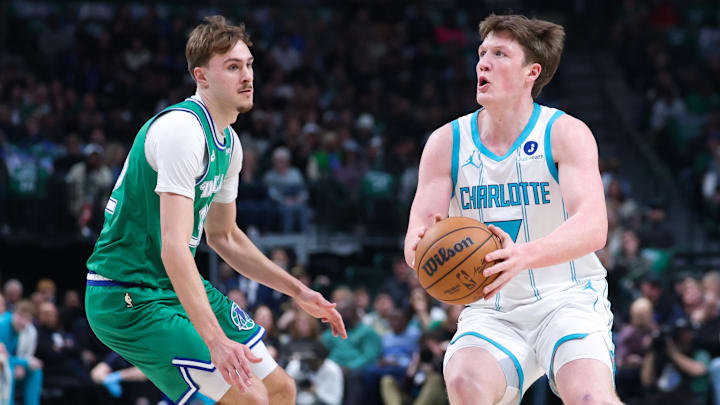 Jan 29, 2026; Dallas, Texas, USA;  Charlotte Hornets guard Kon Knueppel (7) shoots as Dallas Mavericks forward Cooper Flagg (32) defends during the first quarter at American Airlines Center.