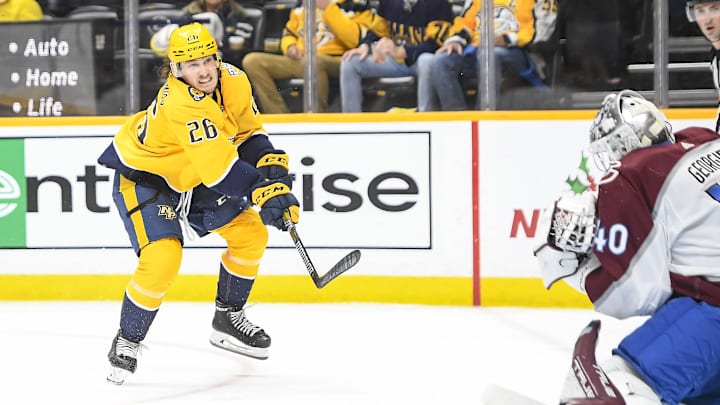 Nov 20, 2023; Nashville, Tennessee, USA;  Nashville Predators defenseman Philip Tomasino (26) takes a shot on goal against the Colorado Avalanche during the third period at Bridgestone Arena. Mandatory Credit: Steve Roberts-Imagn Images