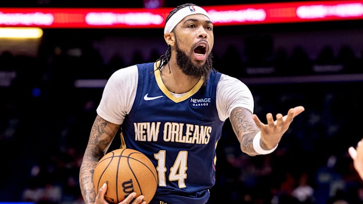 Dec 5, 2024; New Orleans, Louisiana, USA;  New Orleans Pelicans forward Brandon Ingram (14) reacts to a play against Phoenix Suns guard Devin Booker (1) during the first half  at Smoothie King Center. Mandatory Credit: Stephen Lew-Imagn Images