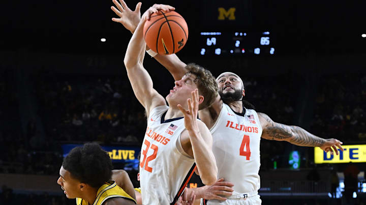 Mar 2, 2025; Ann Arbor, Michigan, USA;  Illinois Fighting Illini guard Kasparas Jakucionis (32) pulls down an offensive rebound away from   Kylan Boswell (4) and Michigan Wolverines guard Phat Phat Brooks (8) in the second half at Crisler Center. Mandatory Credit: Lon Horwedel-Imagn Images