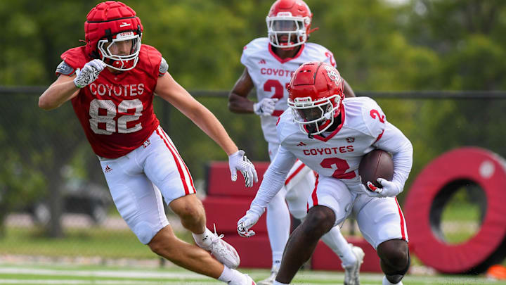 USD’s defensive back Dennis Holden (2) dodges tight end JJ Galbreath (82) on Monday, Aug. 5, 2024, at the Dakota Dome practice field in Vermillion.
