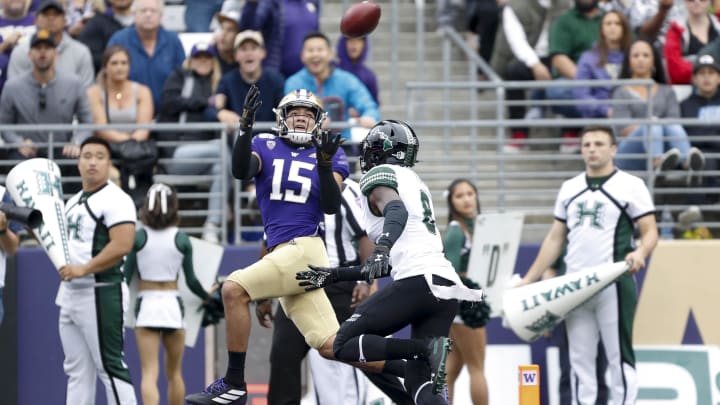 Puka Nacua (15) catches a 28-yard touchdown pass over Hawaii defensive back Eugene Ford (8) during  their Husky Stadium game in 2019.
