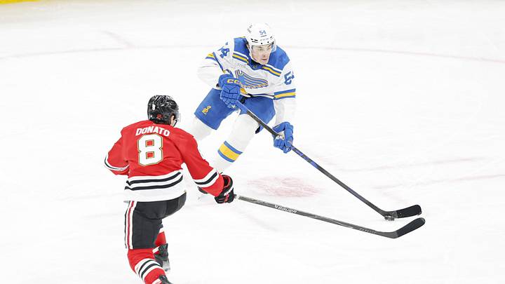 Apr 11, 2026; Chicago, Illinois, USA; St. Louis Blues right wing Dalibor Dvorsky (54) looks to pass the puck against Chicago Blackhawks center Ryan Donato (8) during the second period at United Center. Mandatory Credit: Kamil Krzaczynski-Imagn Images