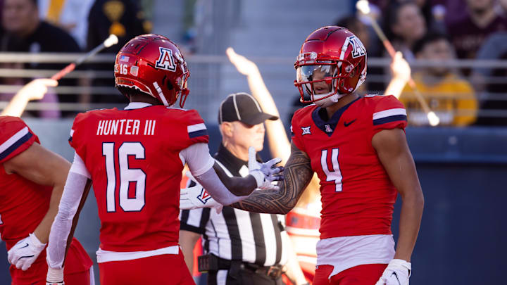 Nov 30, 2024; Tucson, Arizona, USA; Arizona Wildcats wide receiver Tetairoa McMillan (4) celebrates a touchdown with teammate Chris Hunter (16) against the Arizona State Sun Devils in the second half during the Territorial Cup at Arizona Stadium. Mandatory Credit: Mark J. Rebilas-Imagn Images