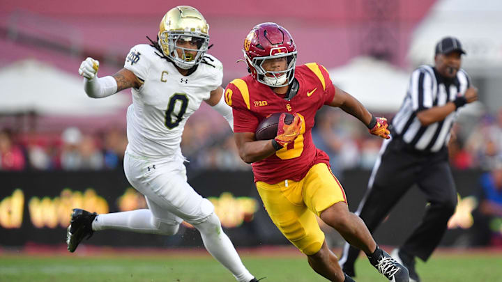 Nov 30, 2024; Los Angeles, California, USA; Southern California Trojans running back Quinten Joyner (0) runs the ball ahead of Notre Dame Fighting Irish safety Xavier Watts (0) during the second half at the Los Angeles Memorial Coliseum. Mandatory Credit: Gary A. Vasquez-Imagn Images Nov 30, 2024; Los Angeles, California, USA; Southern California Trojans running back Quinten Joyner (0) runs the ball ahead of Notre Dame Fighting Irish safety Xavier Watts (0) during the second half at the Los Angeles Memorial Coliseum. Mandatory Credit: Gary A. Vasquez-Imagn Images