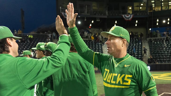Oregon baseball coach Mark Wasikowski, right, congratulates this team after their season-opening win over George Mason at PK Park in Eugene Feb. 13, 2026.