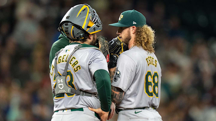 Sep 28, 2024; Seattle, Washington, USA; Oakland Athletics starting pitcher Joey Estes (68) and catcher Shea Langeliers (23) meet at the mound with pitching coach Scott Emerson during the fourth inning  at T-Mobile Park. Mandatory Credit: Stephen Brashear-Imagn Images
