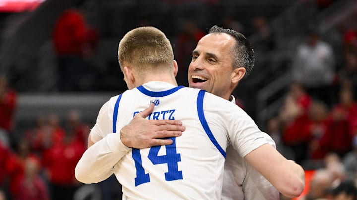 Mar 9, 2025; St. Louis, Missouri, USA;  Drake Bulldogs head coach Ben McCollum hugs guard Bennett Stirtz (14) after defeating the Bradley Braves to win the Missouri Valley Conference Tournament Championship at Enterprise Center. Mandatory Credit: Jeff Curry-Imagn Images