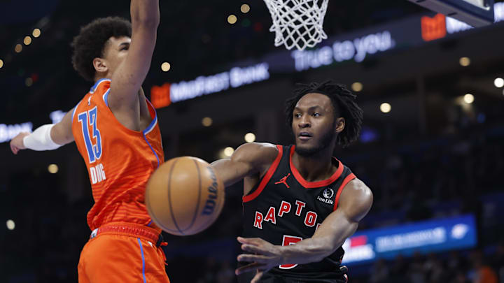 Jan 25, 2026; Oklahoma City, Oklahoma, USA; Toronto Raptors guard Immanuel Quickley (5) passes around Oklahoma City Thunder forward Ousmane Dieng (13) during the second half at Paycom Center. Mandatory Credit: Alonzo Adams-Imagn Images