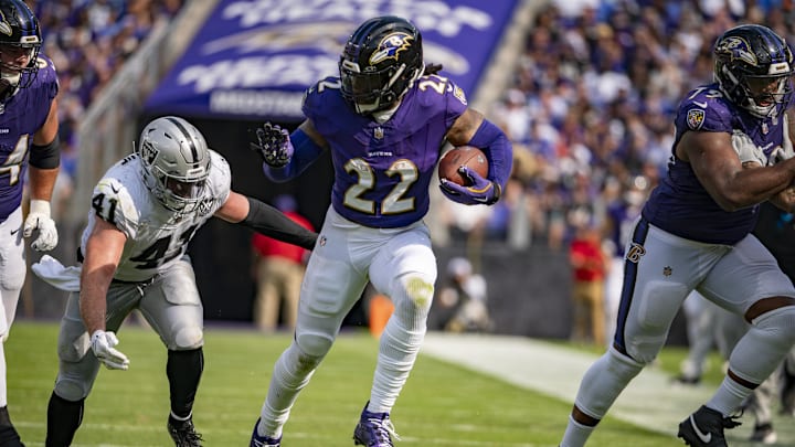 Sep 15, 2024; Baltimore, Maryland, USA;  Baltimore Ravens running back Derrick Henry (22) rushes by Las Vegas Raiders linebacker Robert Spillane (41) during the second half at M&T Bank Stadium. Mandatory Credit: Tommy Gilligan-Imagn Images