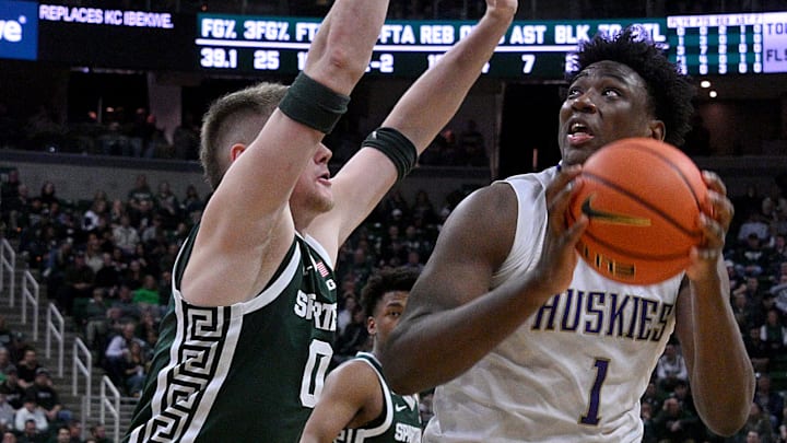 Jan 9, 2025; East Lansing, Michigan, USA;  Washington Huskies forward Great Osobor (1) looks for an opening past Michigan State Spartans forward Jaxon Kohler (0) during the first half at Jack Breslin Student Events Center. Mandatory Credit: Dale Young-Imagn Images