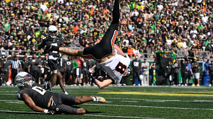 Sep 20, 2025; Eugene, Oregon, USA; Oregon Ducks defensive back Daylen Austin (0) tackles Oregon State Beavers tight end Bryce Caufield (8) during the third quarter of the game at Autzen Stadium. Mandatory Credit: Troy Wayrynen-Imagn Images