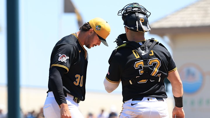 Henry Davis (32) comes to the mound to talk with starting pitcher Paul Skenes (30).