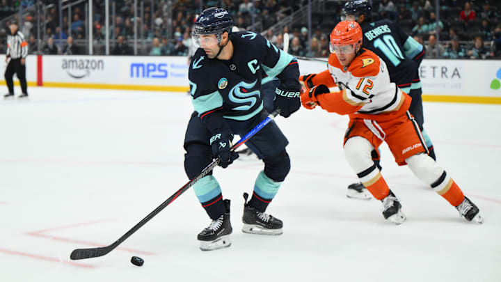Oct 9, 2025; Seattle, Washington, USA; Seattle Kraken right wing Jordan Eberle (7) plays the puck while defended by Anaheim Ducks right wing Sam Colangelo (12) during the third period at Climate Pledge Arena. Mandatory Credit: Steven Bisig-Imagn Images
